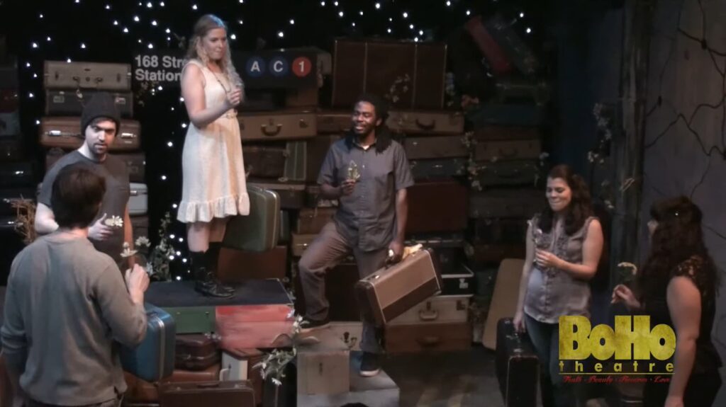 Actors perform amidst a set of vintage suitcases at Boho Theatre